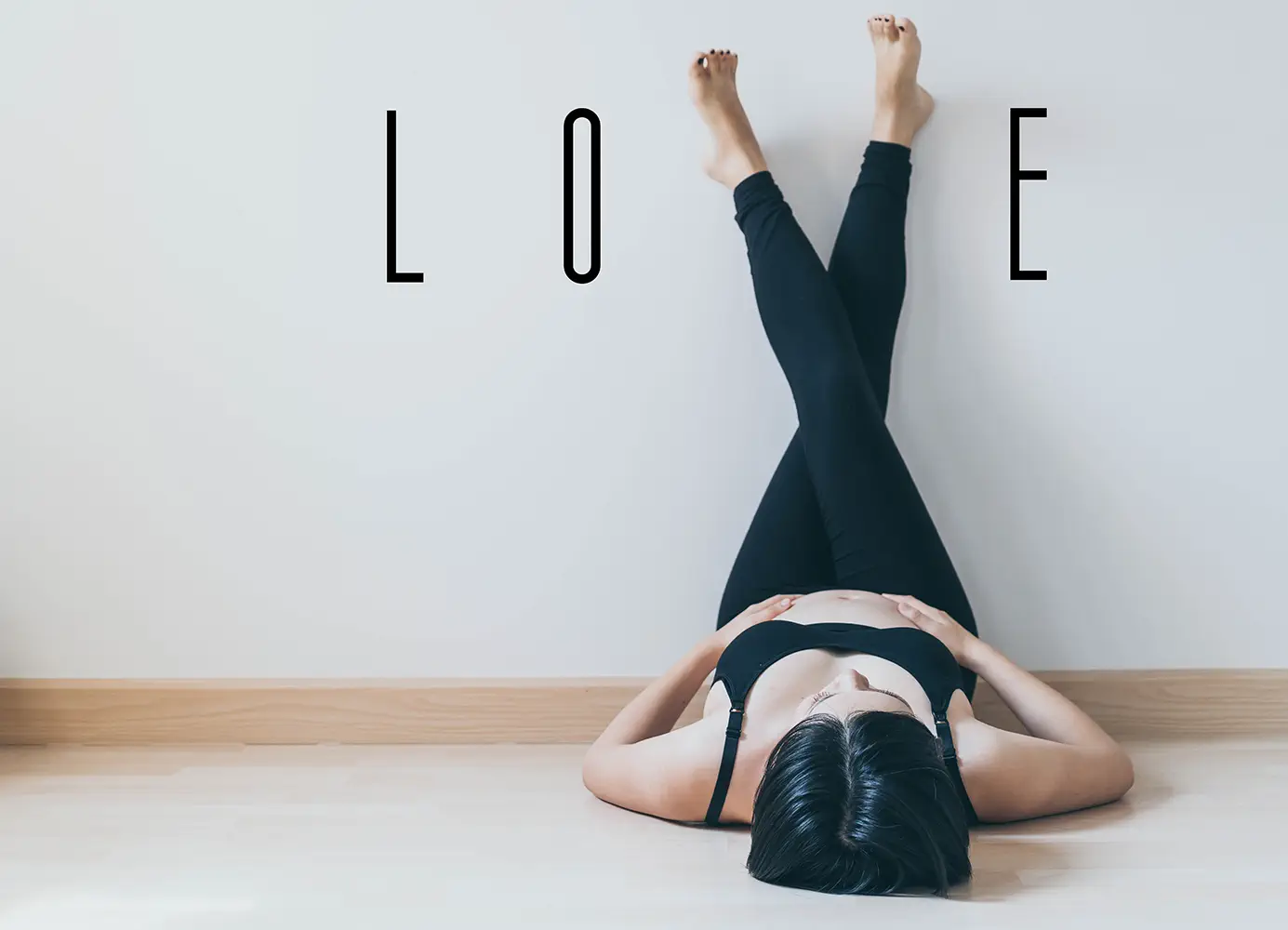 Young beautiful Asian pregnant woman lying with love wordind on